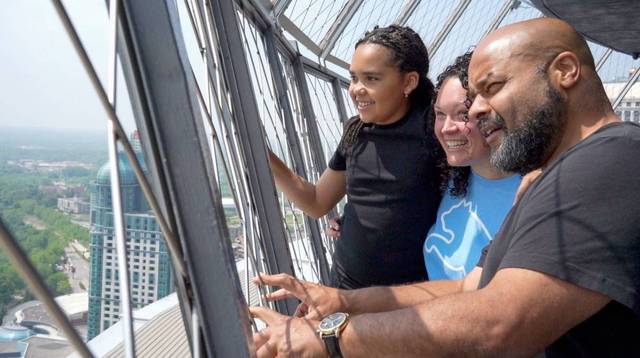 Family enjoying Niagara Falls views from Skylon Tower observation deck.