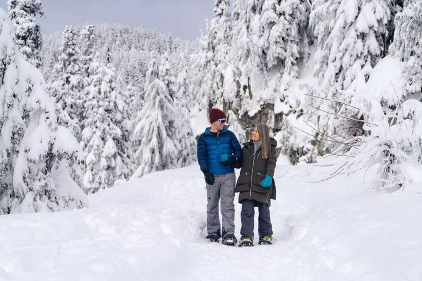 A couple is snow shoeing on Grouse Mountain