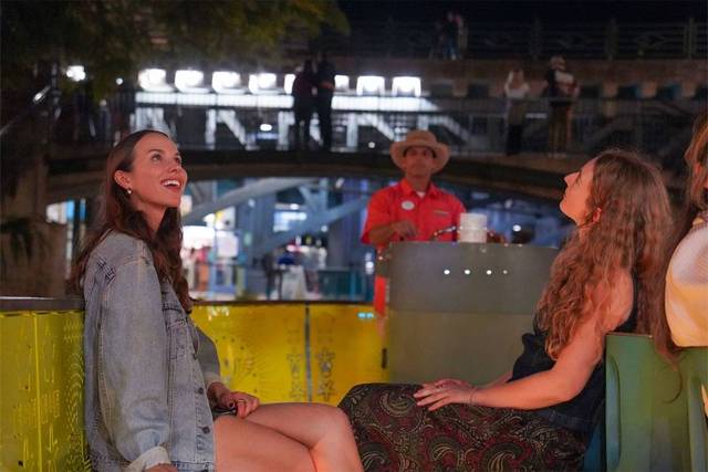 Friends enjoying riverwalk boat tour at night